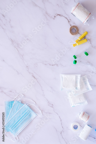Flat lay of some medical supplies against a white marble background