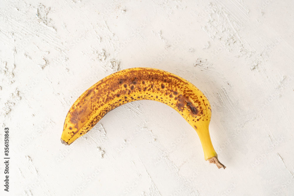 ripe banana on a white textured background with copy space