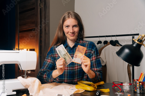 The indignant seamstress looks up with contempt. The concept of low-wage work. Atelier in the home workshop