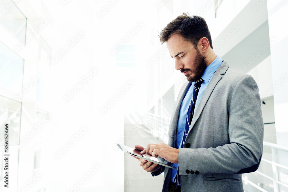 Intelligent male lawyer working on touch pad during work break Intelligent male lawyer working on touch pad during work break