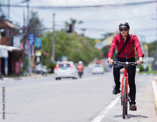 Asian man is cycling to work on the road.