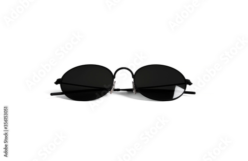 Pair of round shaped hipster eyeglasses for man or woman with light reflection and shadow. Matte black plastic elements. Vacation and travel concept object isolated on clean white background
