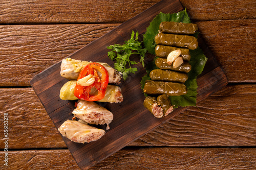 Arabic food. Appetizing cabbage rolls and Rice and mint wrapped in grape vine leaves on wood background