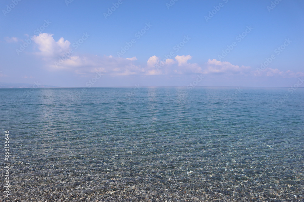 Fototapeta premium sea and sky. Seascape. Calm. The clear blue sea. Sunny morning. Clouds are reflected in the water Transparent sea water. Blue sky. Summer. Holidays at sea. Silence. 