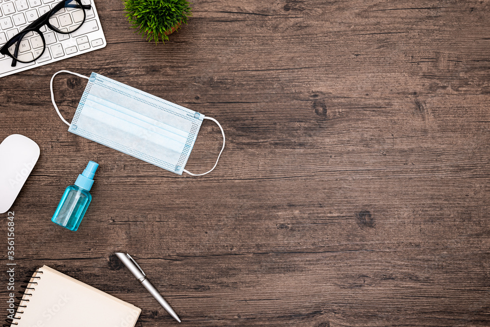 The equipment to protect COVID-19, blue mask and hand cleaner gel for preparing to work from home Isolated on wood desk. The equipment to protect COVID-19, blue mask and hand cleaner gel for preparing to work from home Isolated on wood desk.