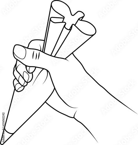 A hand holding a piping bag filled with icing mixture ready to decorate a cake.