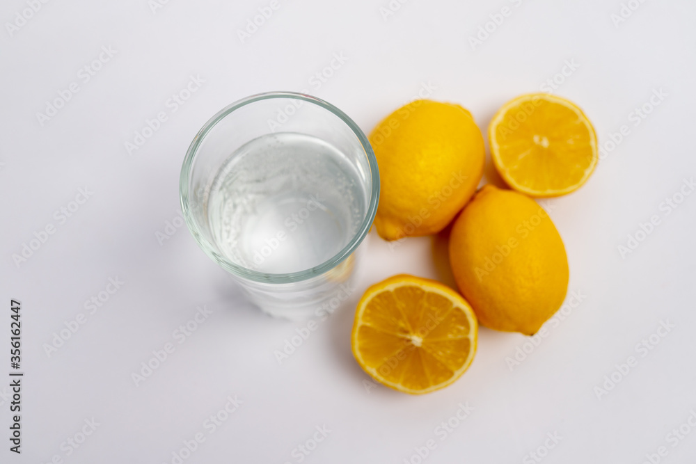 water in a glass with lemons on a white background, lemon water, a glass of water in the morning, healthy lifestyle, place for text