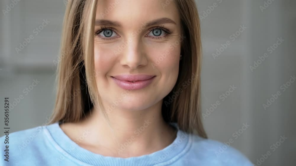 A happy glad young blonde woman is looking to the camera standing at home A happy glad young blonde woman is looking to the camera standing at home