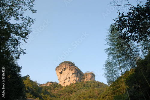 Wuyishan mountains in Fujian Province, China. View of DaWang Peak (Great King Peak) in Wuyi mountains a UNESCO World Heritage site. Bamboo and forest in the foreground. Wuyishan, China. photo