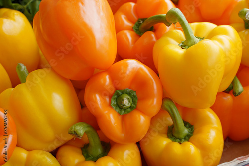 Delicious orange and yellow bell peppers on market stand