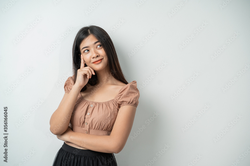 attractive girl with long hair standing while thinking against an isolated background attractive girl with long hair standing while thinking against an isolated background