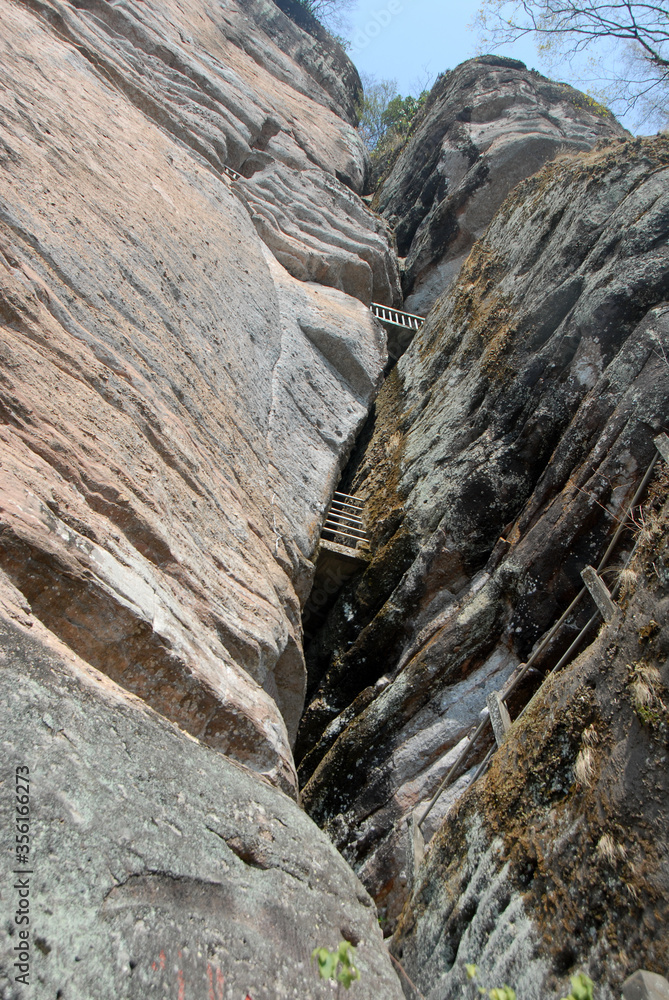 Wuyishan mountains in Fujian Province, China. On the path to DaWang (Great King) Peak. The mountain has steep cliffs and the path is inside the crack in the rock. Wuyishan is a UNESCO site in China. Wuyishan mountains in Fujian Province, China. On the path to DaWang (Great King) Peak. The mountain has steep cliffs and the path is inside the crack in the rock. Wuyishan is a UNESCO site in China.
