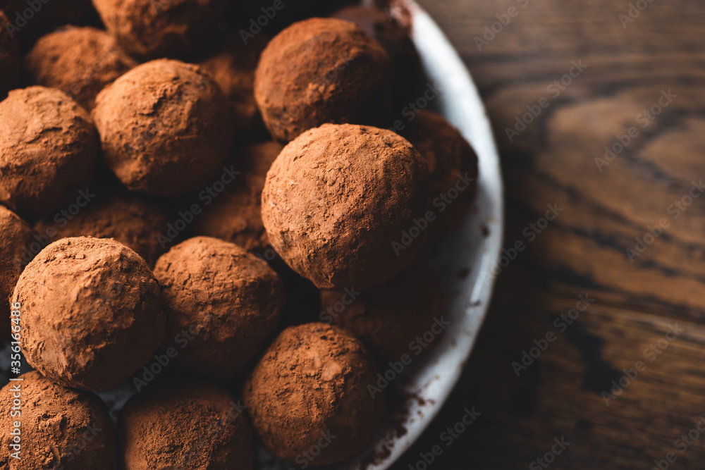 Homemade dark chocolate truffles on wooden background. Heap of cocoa covered chocolate truffles Homemade dark chocolate truffles on wooden background. Heap of cocoa covered chocolate truffles