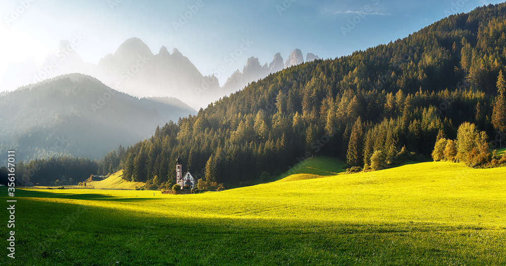 Impressive Athmospheric landcape. Breathtaking view of St Johann Church of Santa Maddalena, with the majestic Dolomites mountains in the background, Val di Funes valley, Italy, Europe. Amazing nature