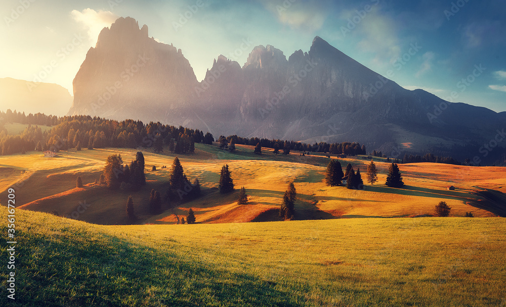 Fototapeta premium Stunning morning Scene. Majestic Moutain peak under sunlight, Alpe di Siusi valley during sunset. Amazing Nature Landscape. Awesome natural Background. Incredible colorful Scenery. Dolomites alps