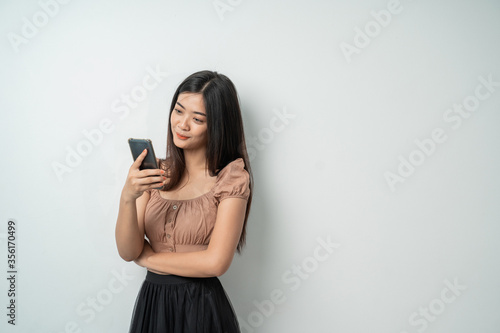 Beautiful girl uses a smartphone gadget with an isolated background