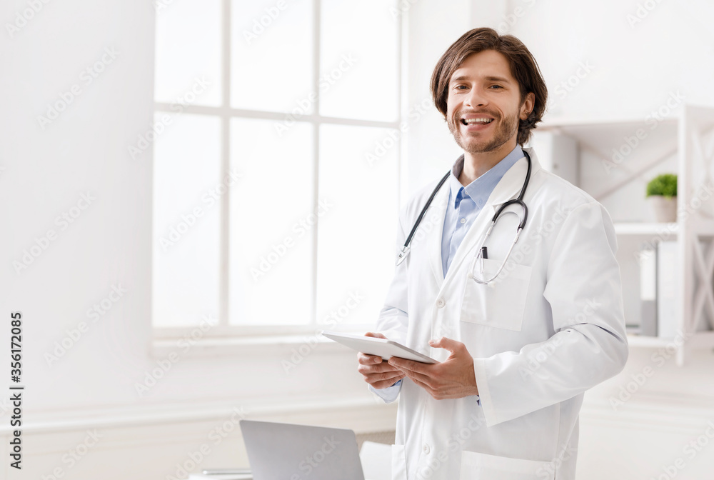 Friendly doctor with digital tablet posing in office Friendly doctor with digital tablet posing in office