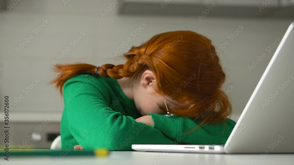 Red-haired kid napping in front of laptop, tired of extra classes and tutoring
