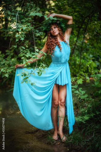 a beautiful young woman celebrates in the woods the solstice day