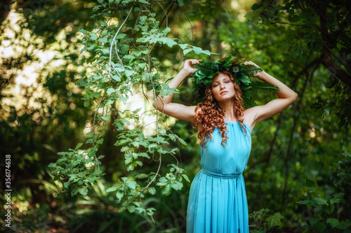 a beautiful young woman celebrates in the woods the solstice day