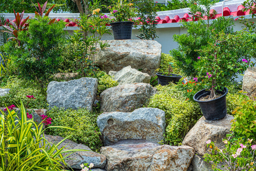 Stone garden with waterfalls and flowers pot decoration in cozy home flower garden on summer. Stone garden with waterfalls and flowers pot decoration in cozy home flower garden on summer.