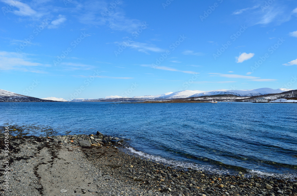 wonderful snowy mountain landscape and blue fjord in sunshine