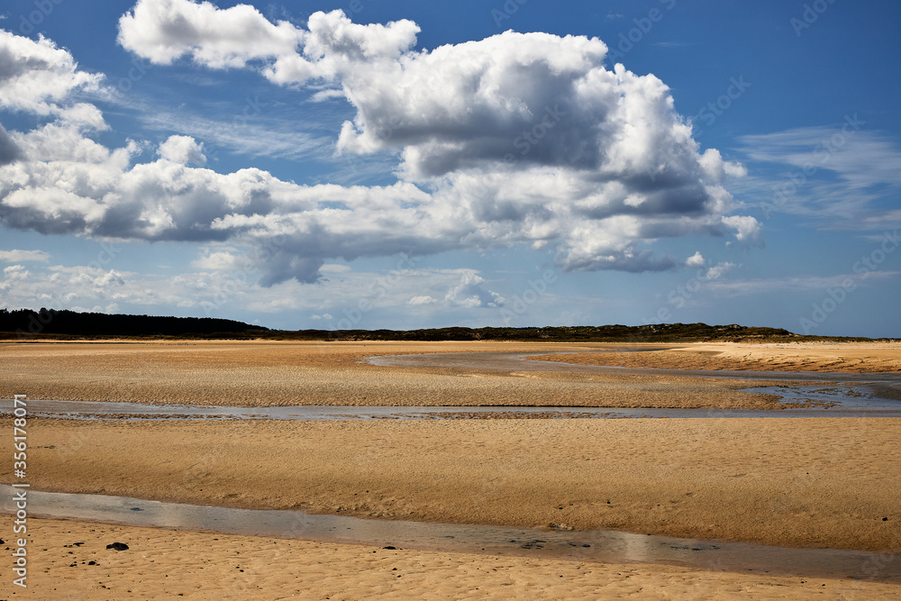 Playa con agua procedente de una laguna en una zona medioambiental protegida