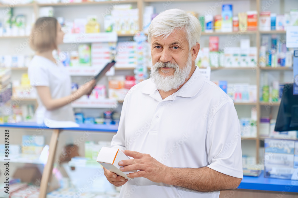 Obraz premium Senior man choosing medicine at pharmacy.