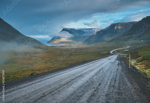 Empty road, mountains and the coast of the fjord. Iceland.