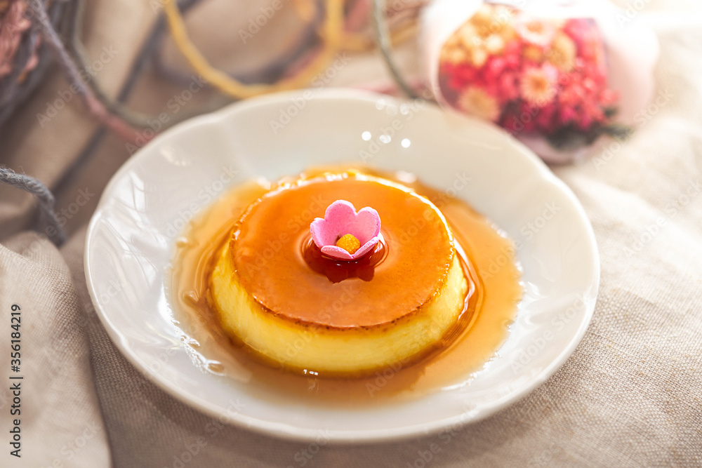 Homemade caramel custard pudding on white plate with brown fabric Homemade caramel custard pudding on white plate with brown fabric