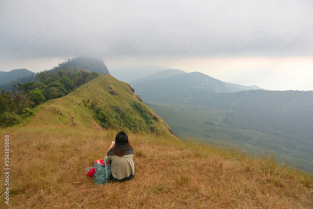 the tourist look around mountains brown grass and cloudy sky landscape