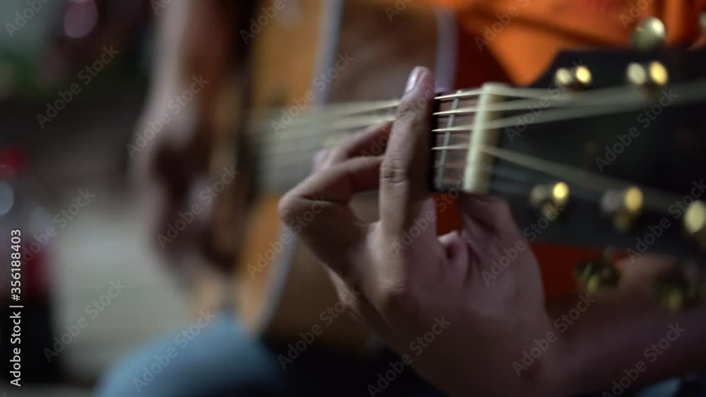 Man's hand playing guitar strings Man's hand playing guitar strings