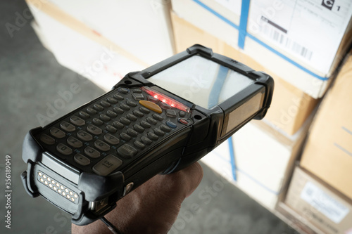 Worker scanning barcode scanner on shipment boxes, Manufacturing cargo warehouse export. Computer equipment for inventory management.