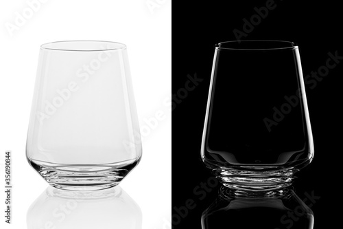 Empty whiskey tumbler glasses on black and white background, isolated