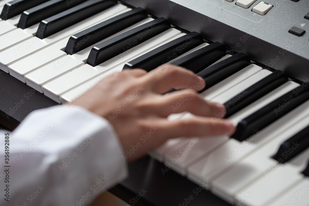 Closeup hand man playing piano. keys in focus.