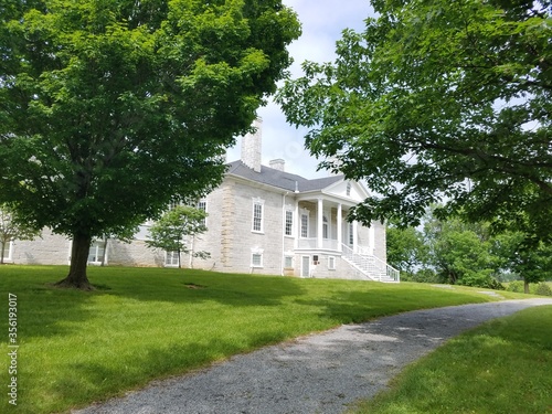 grey stone house with green grass and trees