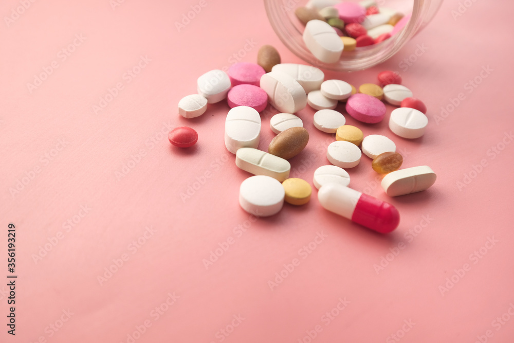 Close up of colorful pills and medicine spilling from contianer Close up of colorful pills and medicine spilling from contianer