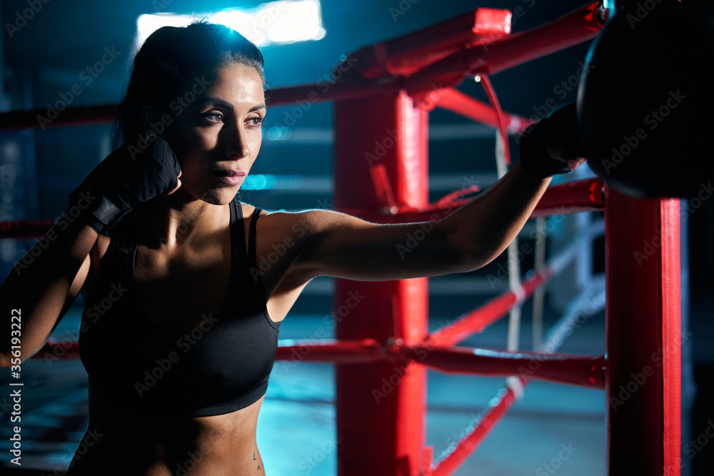 Female fighter hitting small boxing bag.