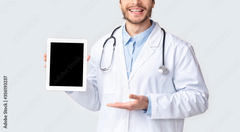 Cheerful doctor presenting medical application on tablet Cheerful doctor presenting medical application on tablet