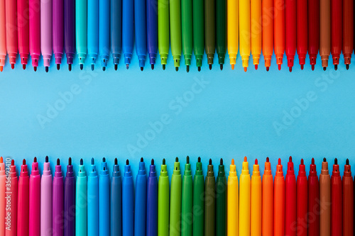 Row of colored pencils with copy space on blue background