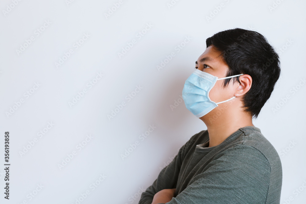 Young man wearing medical face mask, studio portrait. Man Wearing Protective Mask. Man wearing surgical mask for corona virus, isolate background Young man wearing medical face mask, studio portrait. Man Wearing Protective Mask. Man wearing surgical mask for corona virus, isolate background