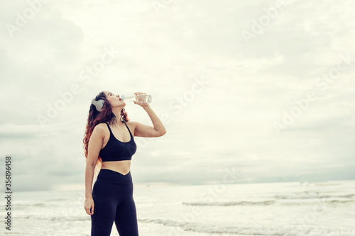 Beautiful woman standing holding a bottle of drinking water show