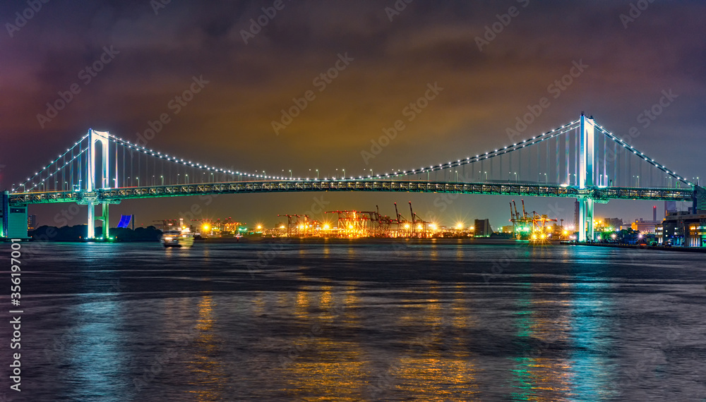 Rainbow Bridge colorfully illuminated at night, spanning across Tokyo Bay in Tokyo Japan Rainbow Bridge colorfully illuminated at night, spanning across Tokyo Bay in Tokyo Japan
