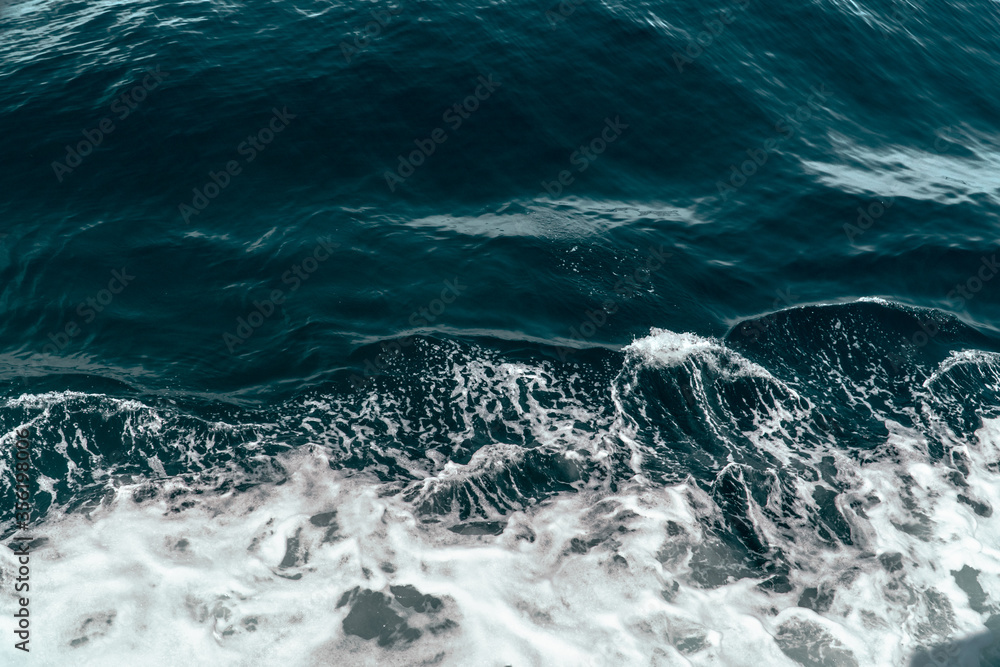Top aerial view of deep blue waters of ocean with white foam. Drone travel summer background Top aerial view of deep blue waters of ocean with white foam. Drone travel summer background