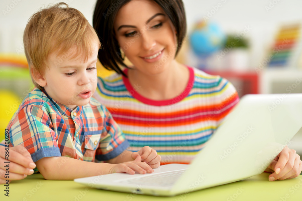 Portrait of mother and son using laptop together Portrait of mother and son using laptop together