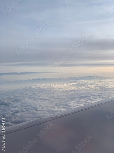 Sunset up above the clouds viewed inflight on a passenger airplane.