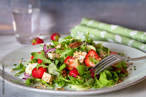 Feta cheese strawberry cucumber rocket (arugula) salad with pecan nuts - healthy vegetarian food