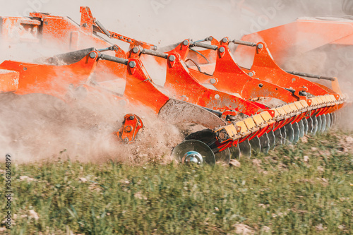 Fotografia, Obraz Agricultural equipment shreds the plowed land