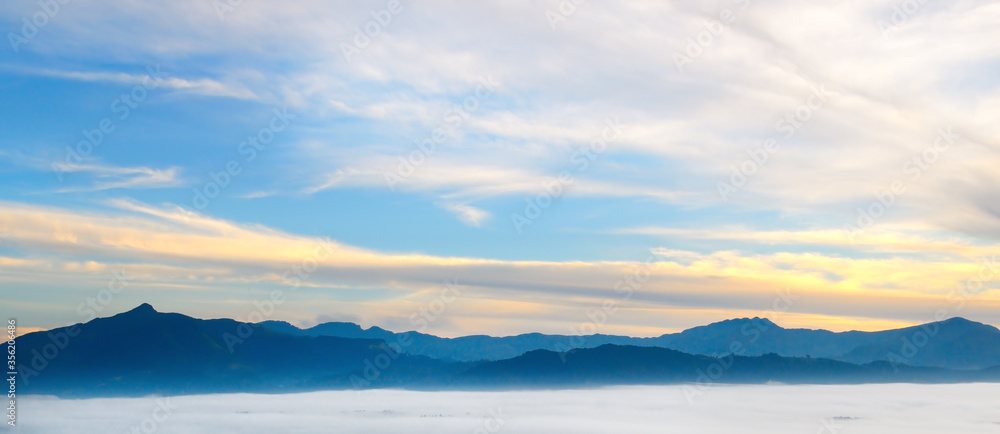 Sunrise in mountains, fog and cloud mountain valley landscape. Wide photo.