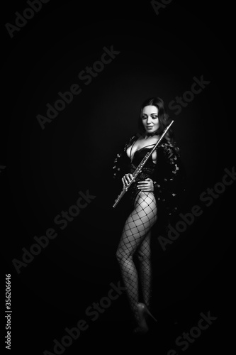 Female girl artist in suit with flute on black background. Flute in hand. Player with orchestra music instrument. Isolated on black. Author's space. Large background space for an inscription or logo